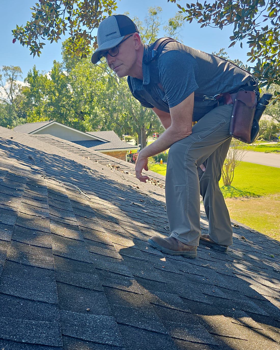 Dan Fryer, TrueHome's licensed Florida home inspector, up on a roof checking the shingles