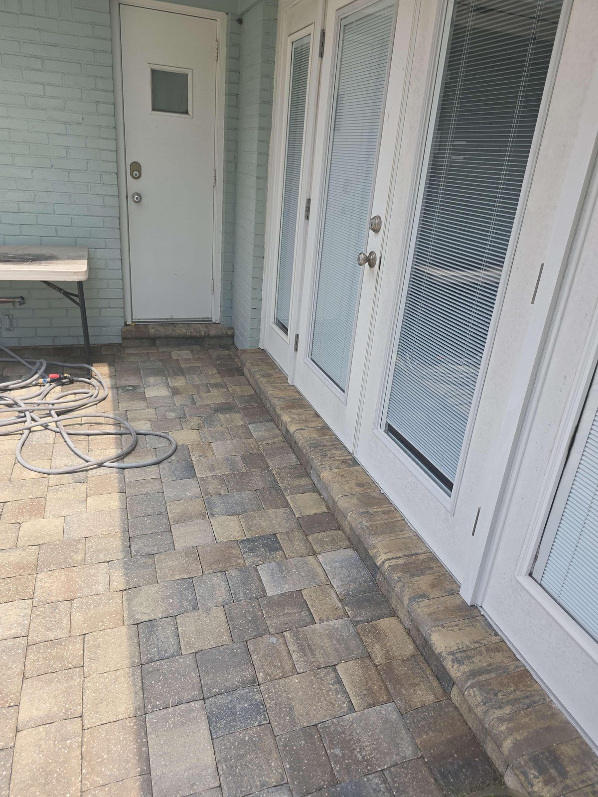 A narrow concrete landing at a rear entry door, showing the door's outswing arc extending beyond the edge of the landing surface