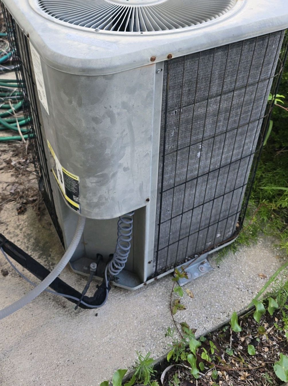 Outdoor HVAC condensing unit inspected for refrigerant type and age