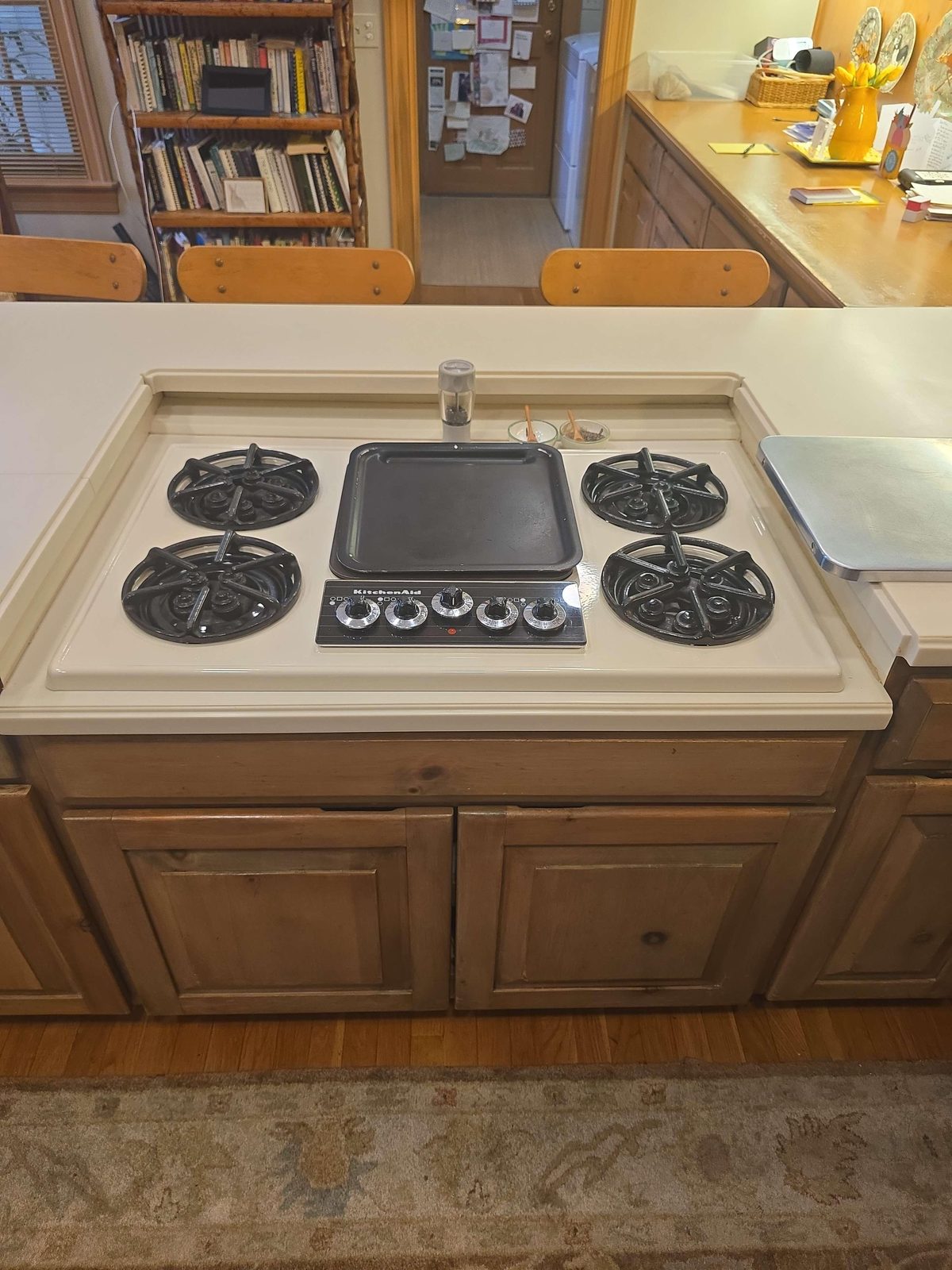 Close-up of a gas range cooktop showing the left front burner area and the right front burner control knob